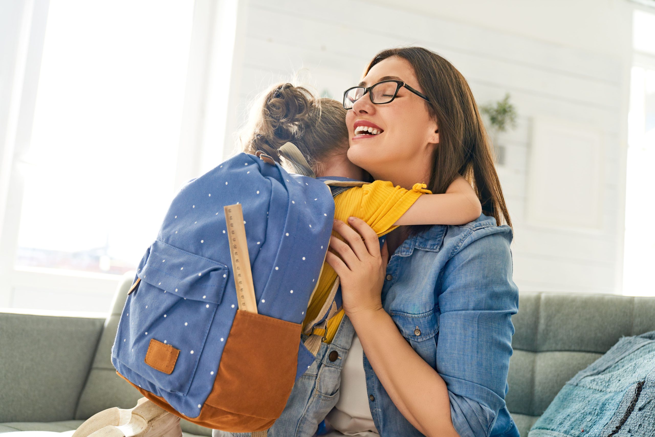 A mother embraces her daughter in a warm hug before dropping her off at childcare.